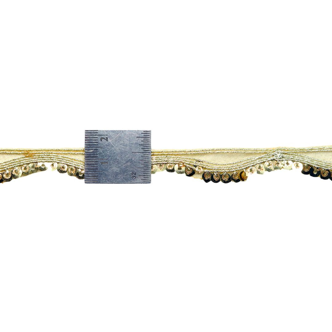 Decorative trim with beads and a ruler for scale on a white background